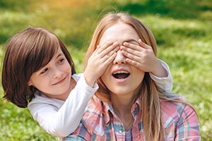 Little girl covering womans eyes