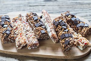 Wood cutting board with Chocolate Cherry Oat Bars on top