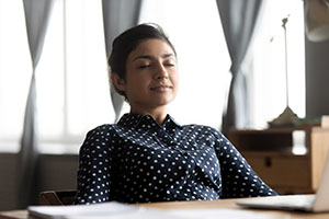 a woman relaxing sitting down with her eyes closed